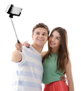 十几岁的情侣用自己的手机拍照片，白色的手机隔离