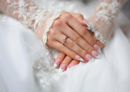 有戒指和婚礼指甲的新娘的手