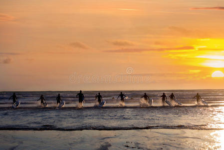 一群年轻的冲浪者在海滩上冲浪
