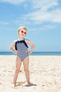 快乐的女孩，在一个白色的沙滩穿上泳装的全长画像