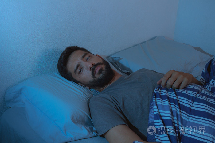 睡眠障碍,失眠.小胡子男人躺在床上醒着