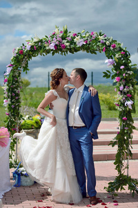美丽的新娘与新郎在婚礼拱门附近