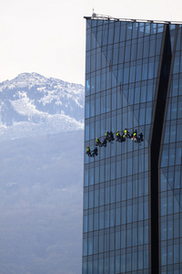 六个登山者洗窗户和玻璃幕墙的摩天大楼