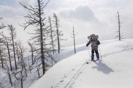 男性的滑雪和冬季山区和森林的背包徒步旅行