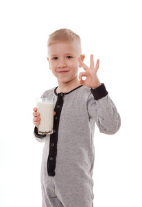 男孩在喝牛奶，孤立在白色背景上的睡衣