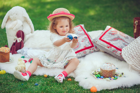 快乐的孩子坐在草地上订货与复活节装饰