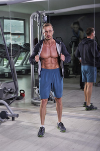 帅强大健壮的男人在健身房里摆姿势。与六包 完美的腹部和胸部强健美