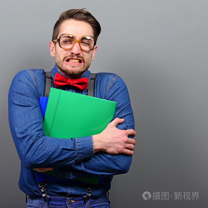 对灰色拿着书与复古眼镜的书呆子的肖像