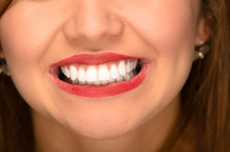 特写年轻女人嘴里露出白色的健康牙齿
