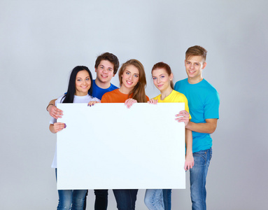 群抱着一个空白的板，白色背景上孤立的年轻朋友