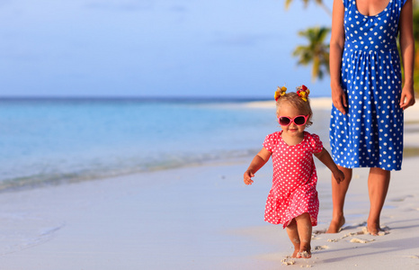 可爱的小女孩，与母亲在海滩上运行