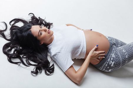 怀孕的女人躺在地板上