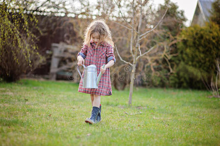 带浇水的女孩子可以在春天的花园里帮忙