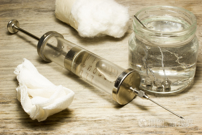 用针在一个木制的背景上铁老式玻璃注射器