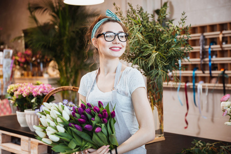 女人花店鲜花店里拿着白色和紫色的郁金香