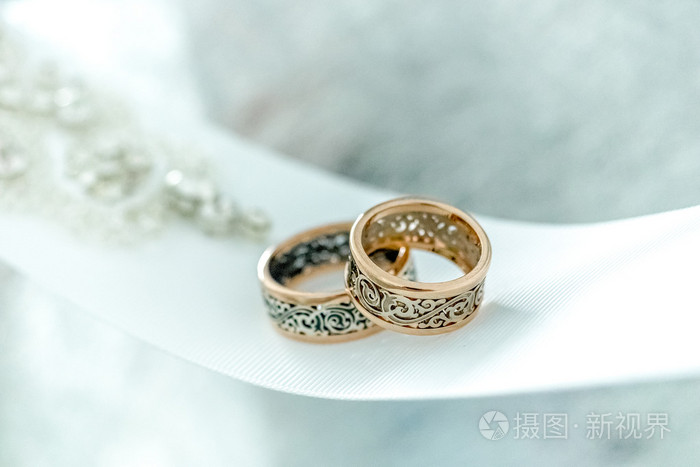 与罕见的设计白色的广泛功能区上的两个结婚戒指