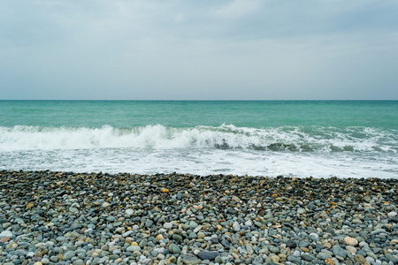 海浪在孤独的卵石的海滩，形成喷雾剂