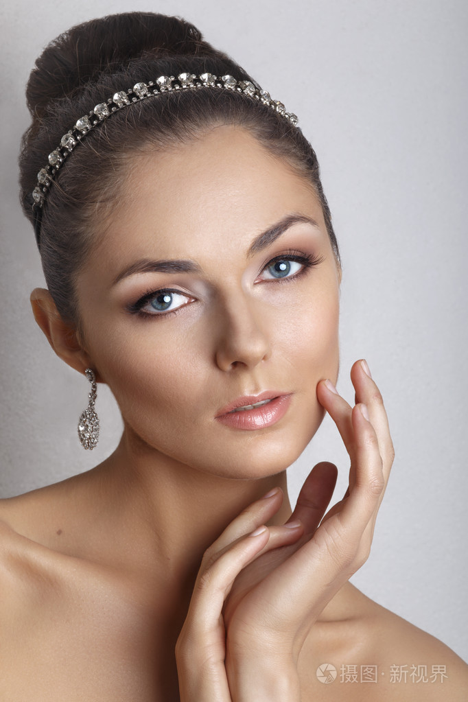 与时尚婚礼发型-白色背景上的美丽新娘。年轻