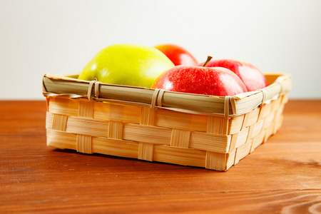 新鲜成熟的红苹果，木制背景上一篮子