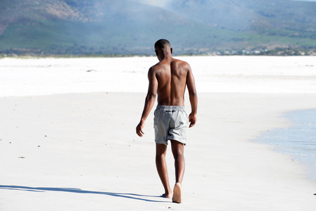 赤脚走在海滩上的年轻人图片