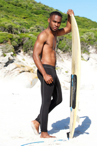 年轻的非洲裔美国人与在海滩冲浪板