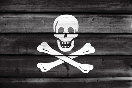 传统的骷髅的海盗旗，画在旧的木头上