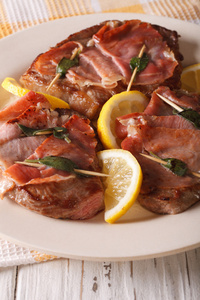 意大利牛肉煎火腿卷与鼠尾草 火腿和柠檬的特写。垂直