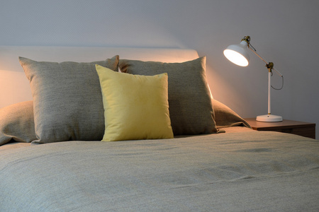 舒适的睡房内政部与枕头和床头柜上的阅读灯