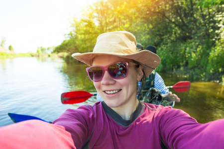 自拍照。年轻人在美丽的大自然中的一条河上划皮艇