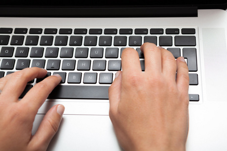 女人使用笔记本电脑键盘上打字