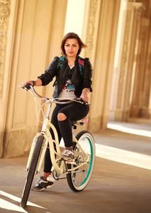 年轻的女子在日落古城的老式自行车