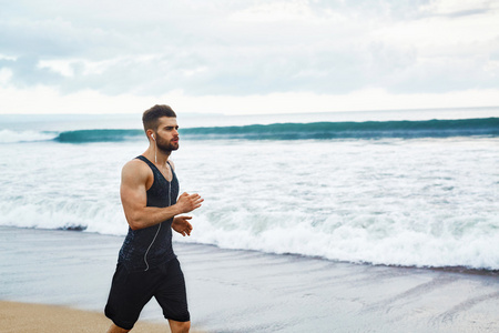 运行在室外健身锻炼在海滩上慢跑的男人。体育