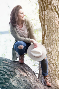 年轻女人站在一棵树在水边