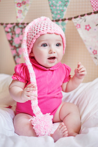 在床上的粉红色针织帽子初生女婴