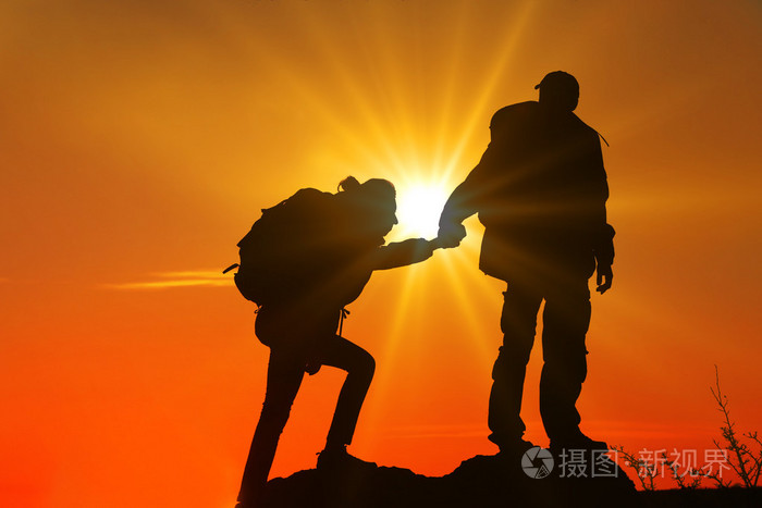 在两个登山者之间帮助双手获得阳光