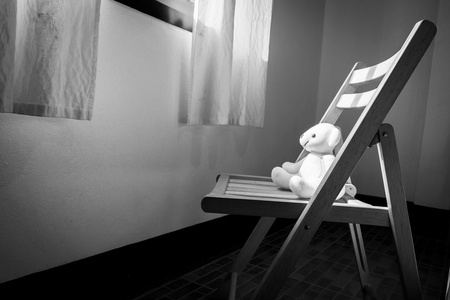 可爱的泰迪熊，独自一人坐在窗边的椅子上