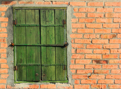旧红砖砌成墙上用螺栓固定木制百叶窗