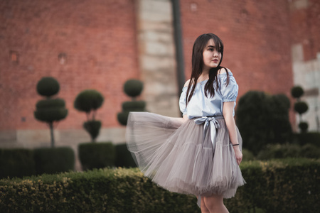 年轻的亚裔女孩，老克拉科夫构成的现代服饰