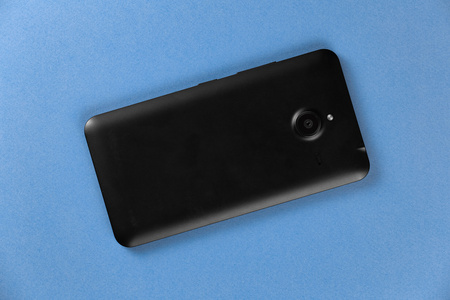 在蓝色背景上的黑色的顶视图智能手机