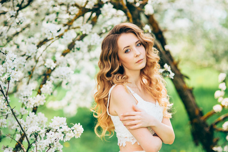 春天美丽的女孩, 金发女郎, 站在一个盛开的苹果果园