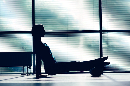 健身 运动 训练和生活方式的概念   做普拉提地板与泡沫辊形的身体撞在窗户上的女人