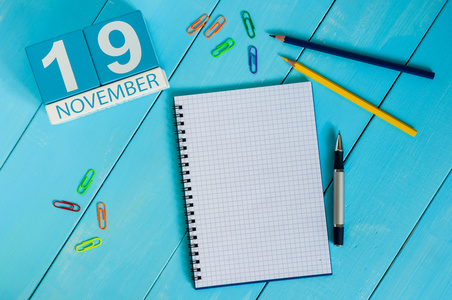 11 月 19 日。11 月 19 日的形象在蓝色背景上的木制彩色日历。秋季的一天。文本为空的空间