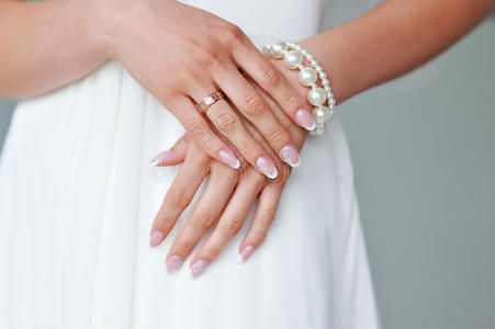 漂亮的女性手与指甲对白色连衣裙