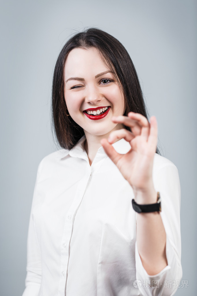 年轻漂亮的女人显示 ok 的手势