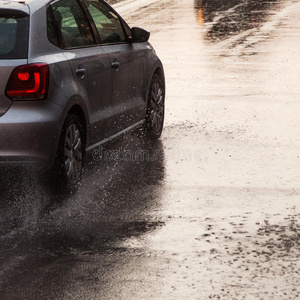 大雨下在潮湿的街道上的汽车
