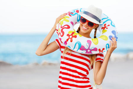 海滩女人快乐和丰富多彩，戴着太阳镜和沙滩帽，在旅行假期享受夏日乐趣