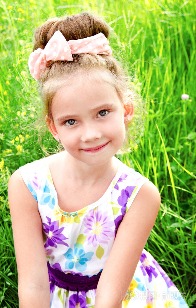 可爱微笑的小女孩,在夏日的草地上