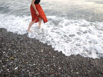 在女孩赤脚在岸边的红裙子图片