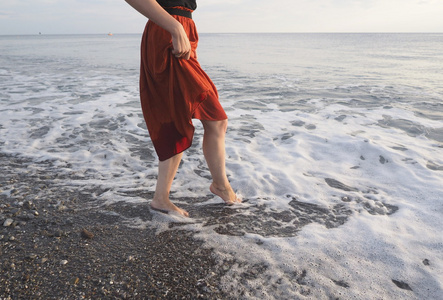 在女孩赤脚在岸边的红裙子图片