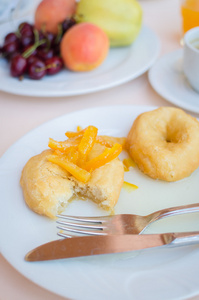 早餐包括带甜甜橙果酱的甜甜圈图片